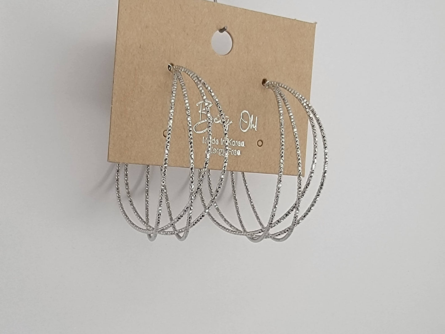 LAZER CUT CRISS CROSS HOOP EARRINGS.