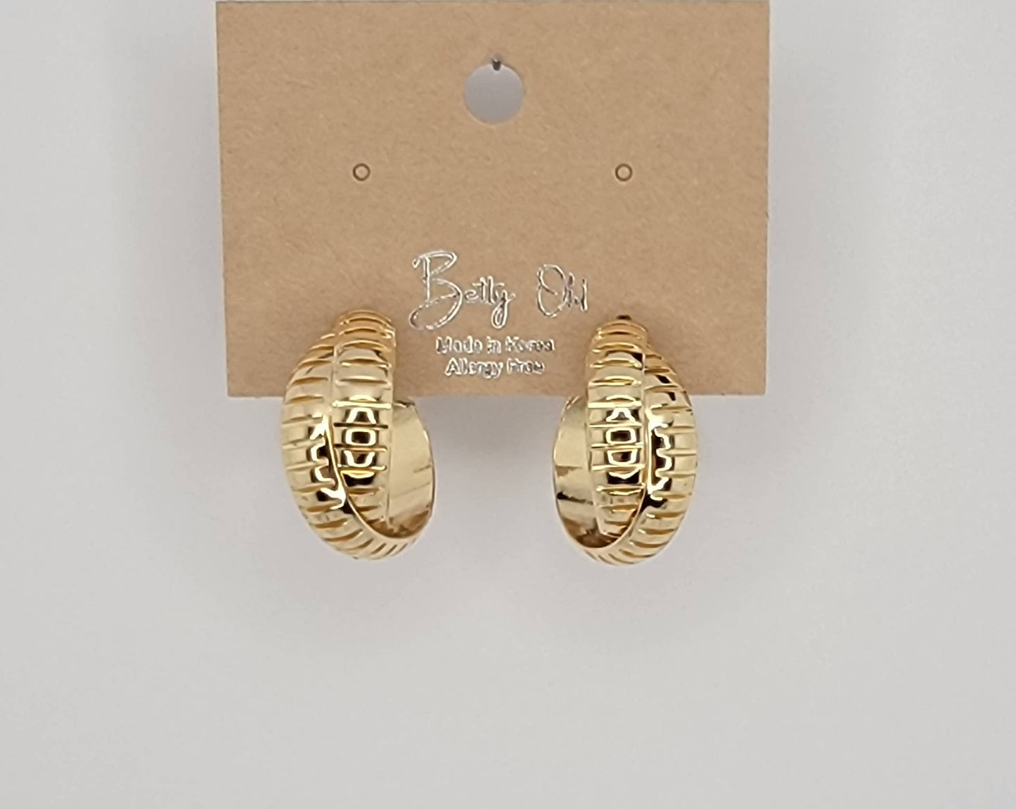 X CROSS HOOP EARRINGS.