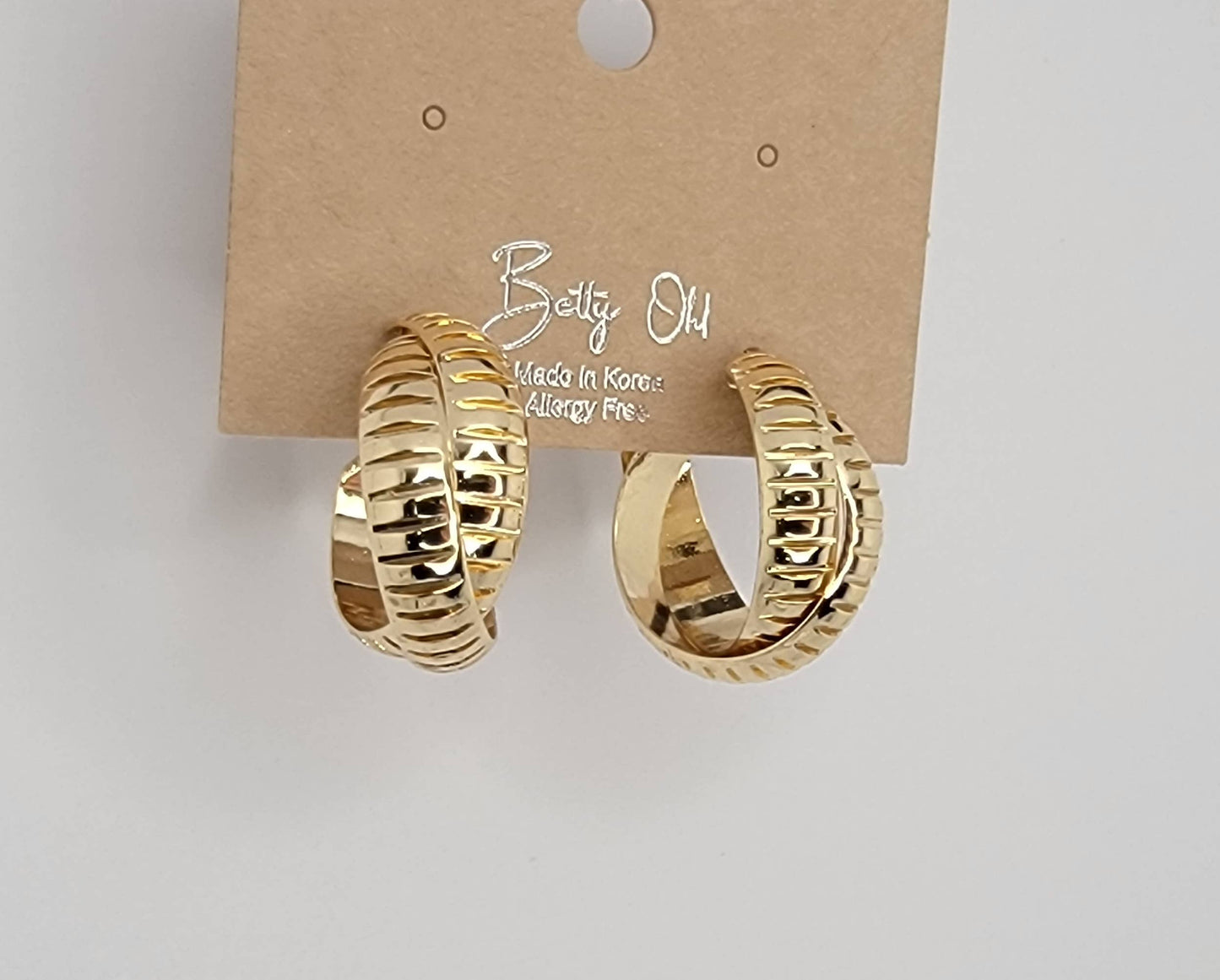 X CROSS HOOP EARRINGS.
