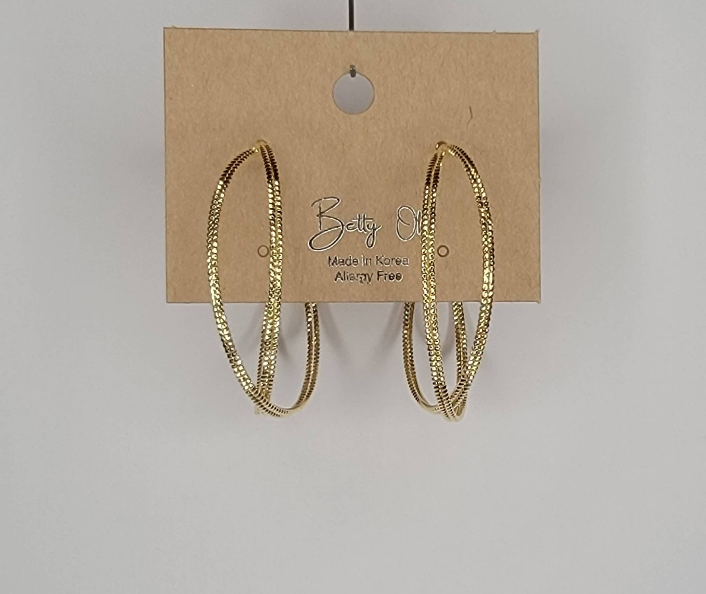 LAZER CUT CRISS CROSS HOOP EARRINGS.
