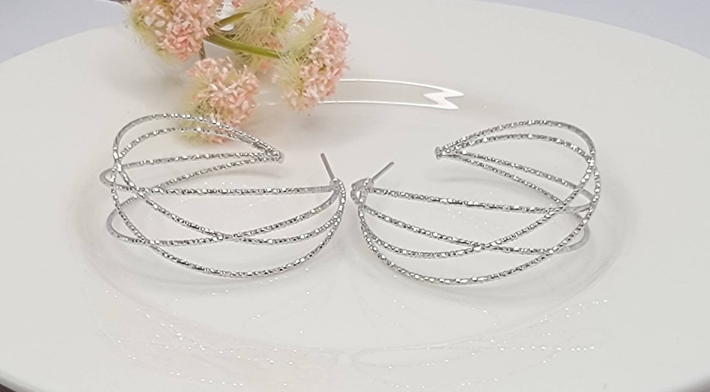 LAZER CUT CRISS CROSS HOOP EARRINGS.